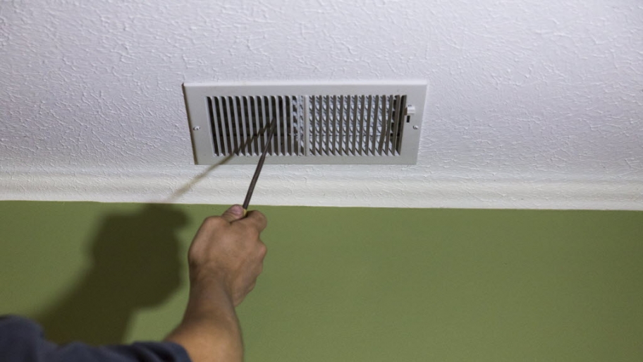 air duct cleaning worker checking vent